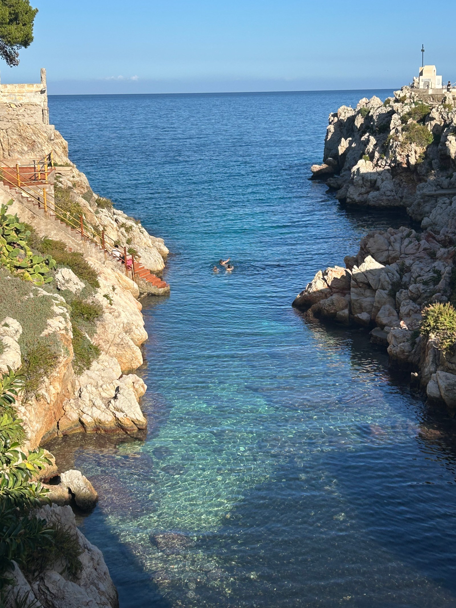 Clear blue water at the rocky caletta in Sant'Elia, Sicily